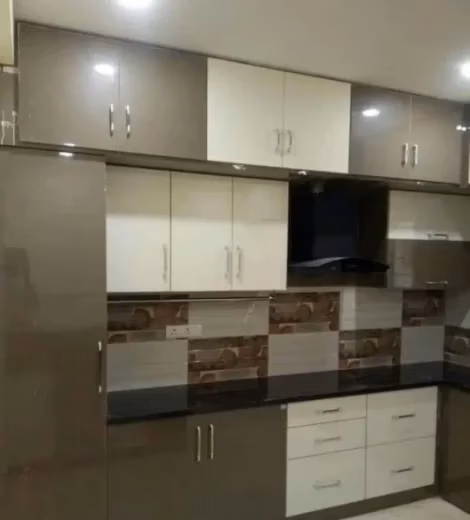 Modern modular kitchen setup with high-gloss cabinets and countertop in Chennai